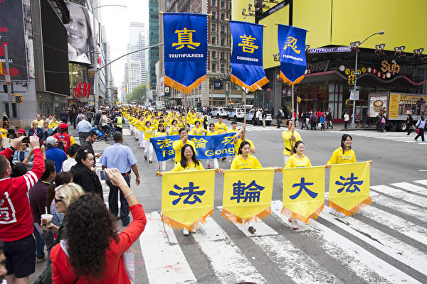 图为法轮功学员在纽约曼哈顿举行庆祝“世界法轮大法日”的大游行，路人纷纷拍照。 （季媛/大纪元）